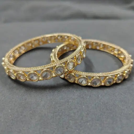 AIVY LUXE gold bridal chuda bangle set with clear gemstone accents on dark background