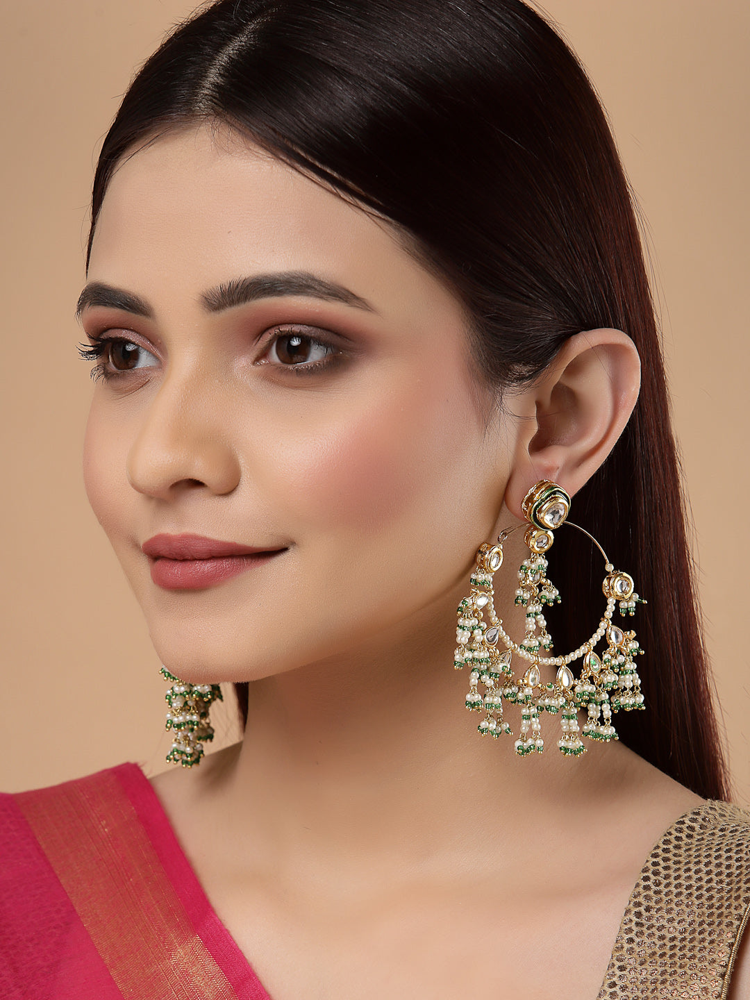 AIVY LUXE traditional Indian dangler earrings worn by woman with gold and green embellishments