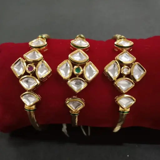 AIVY LUXE diamond cut kundan bangles set with gold plating and clear stones on red cushion