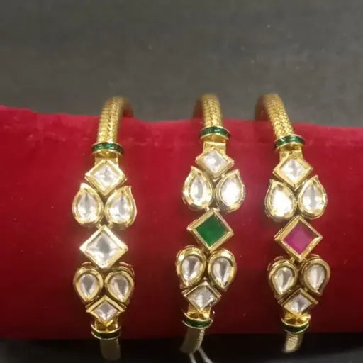 AIVY LUXE gold kundan teardrop bangles set with green and pink stone accents on a red display