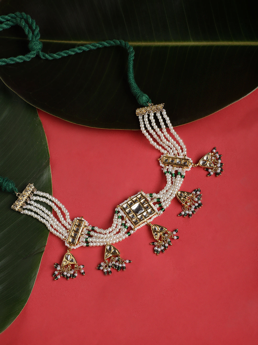 AIVY LUXE luxury pearl choker necklace with intricate gold and green detailing on red background