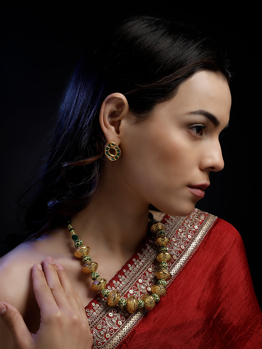 A woman wearing AIVY LUXE unique shamrock statement earrings with traditional jewelry and a red saree