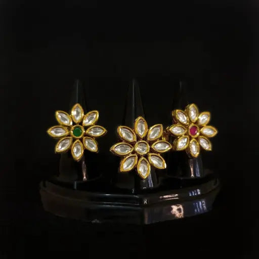 Golden lotus-style kundan rings arranged in floral shapes