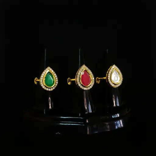 Teardrop-shaped rings in green, red, and white stone combinations
