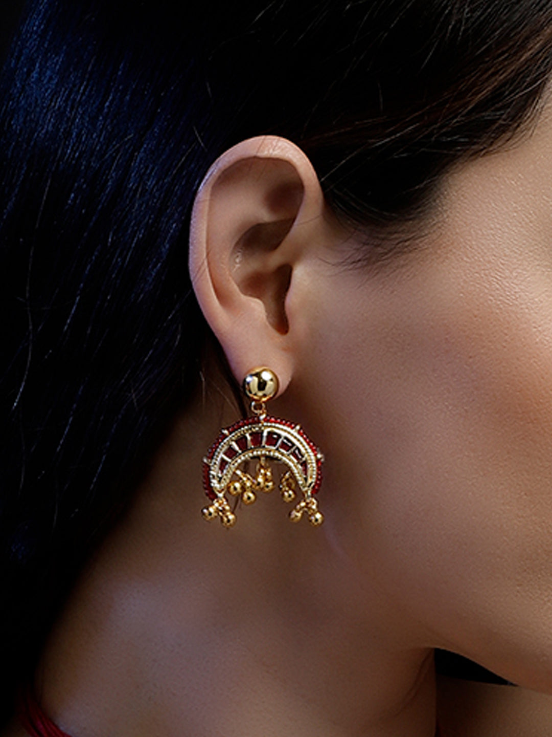 AIVY LUXE red and gold statement earrings worn on ear with intricate detailing and dangling beads
