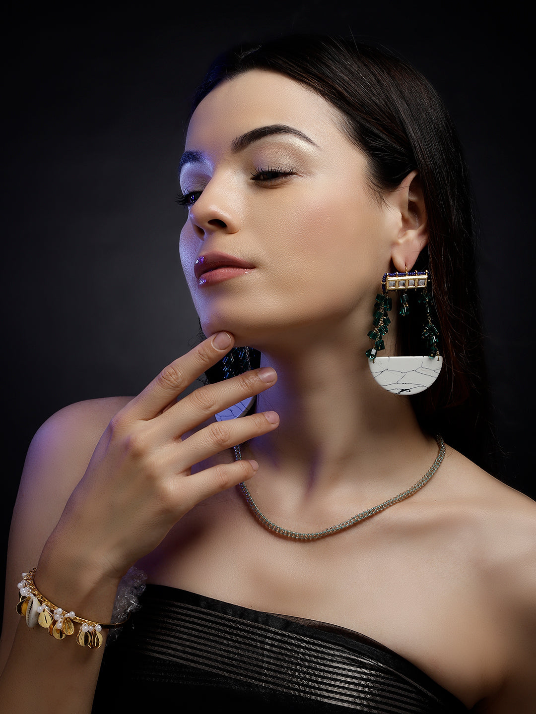 AIVY LUXE artisan statement layered necklace worn by woman with black strapless top and large earrings