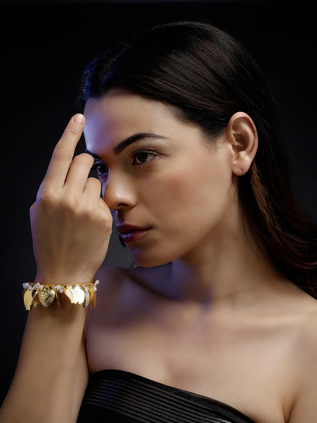 AIVY LUXE designer leaf dangle bracelet in gold worn on wrist with multiple leaf charms