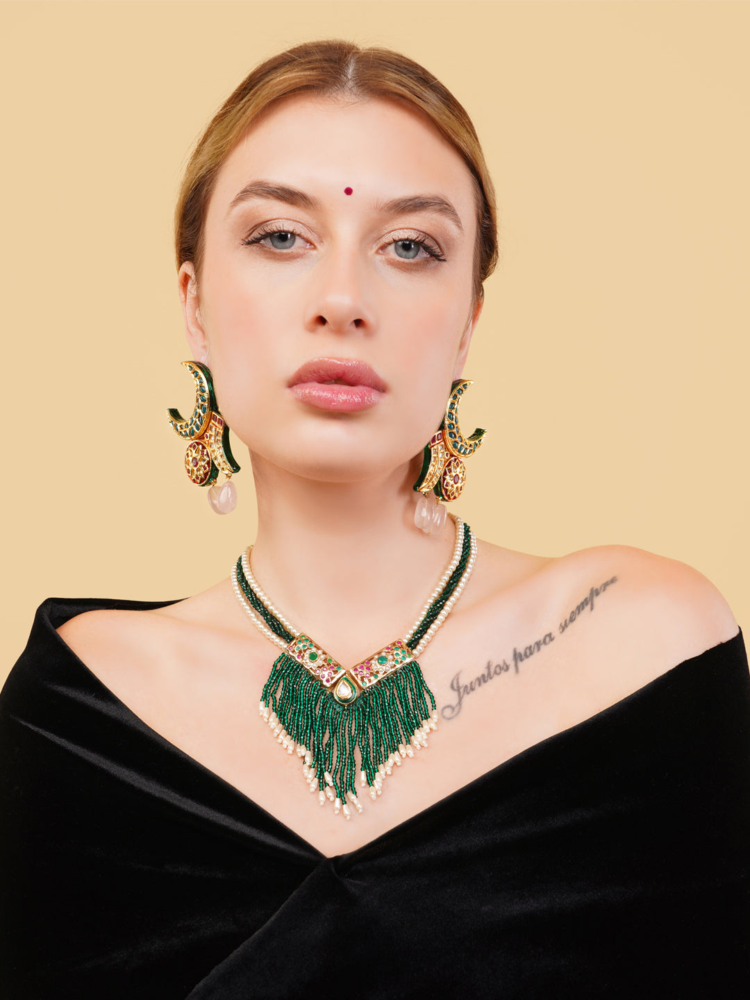 AIVY LUXE green beaded fringe necklace with gold accents worn by a woman in a black off-shoulder top