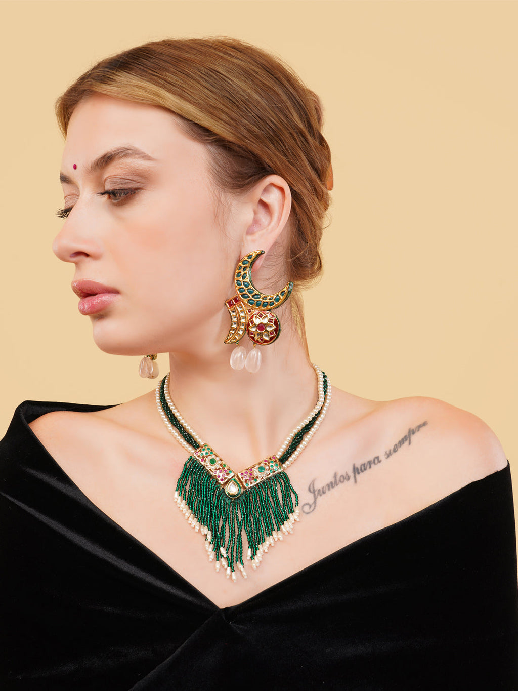 AIVY LUXE green beaded fringe necklace worn by a woman with gold and green earrings and a black off-shoulder top