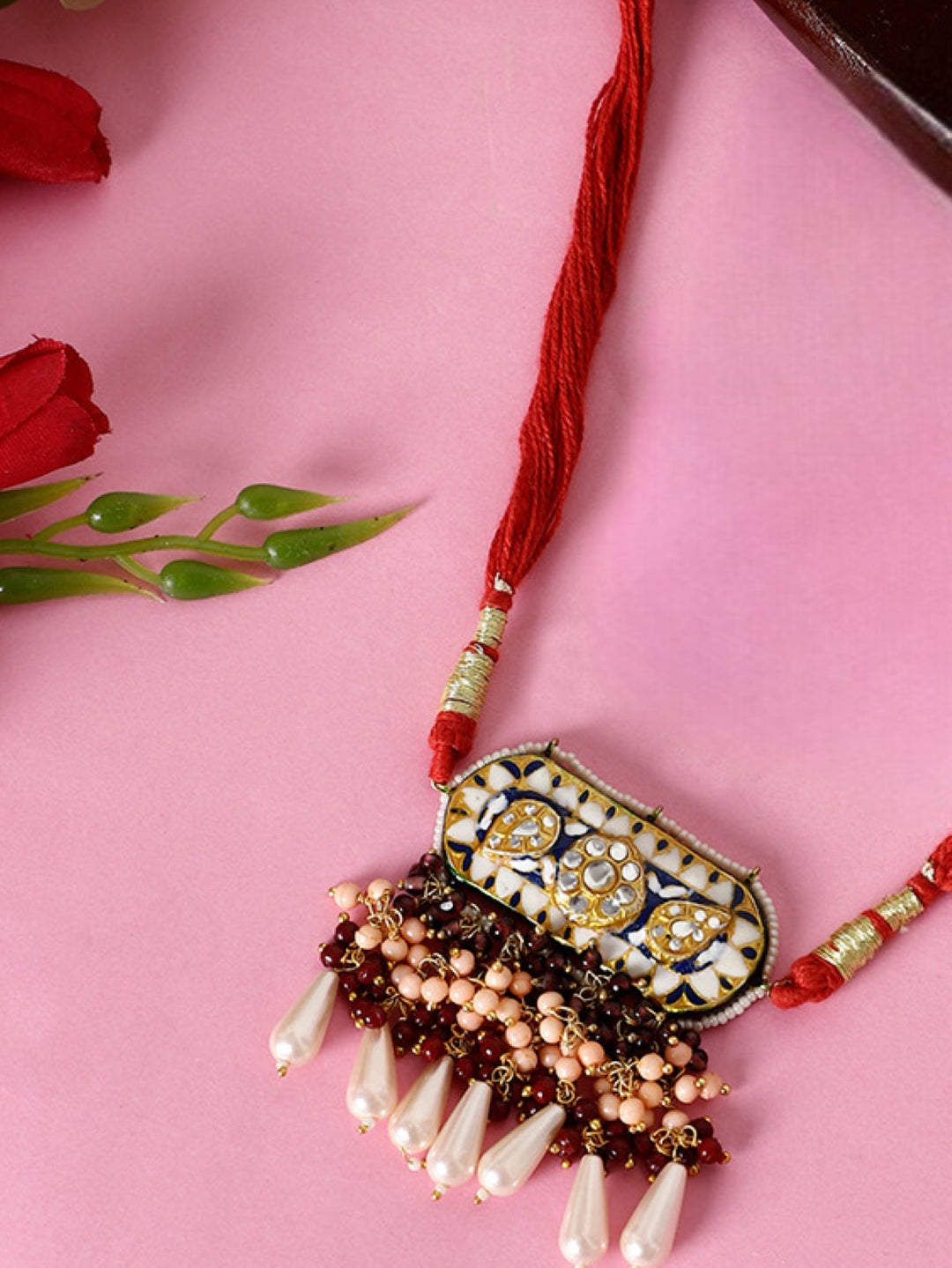 Handcrafted bajuband online by AIVY LUXE with detailed pearls and red thread on pink background