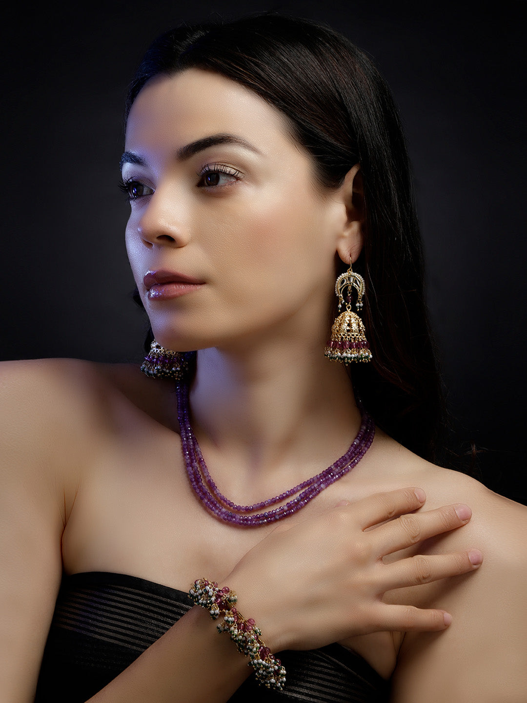 AIVY LUXE layered charm necklace with purple beads worn by a woman with matching earrings and bracelet