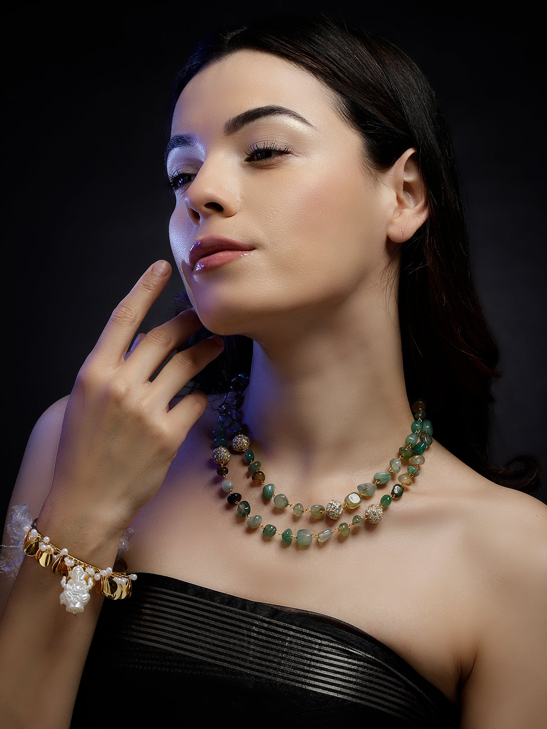 AIVY LUXE layered green gemstone necklace worn by woman with dark hair and black strapless top