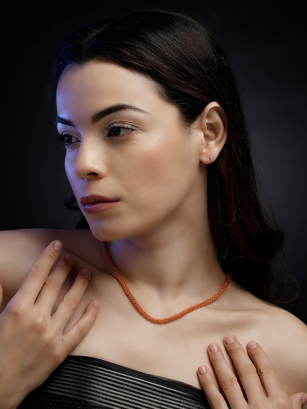 AIVY LUXE orange beaded necklace for women worn by a woman with dark hair and a black strapless top