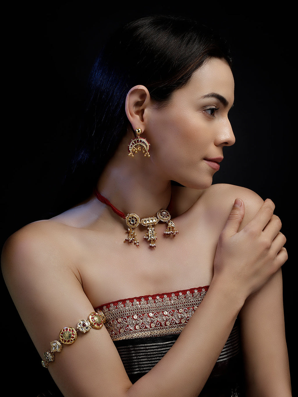 AIVY LUXE red and gold statement earrings worn by woman with matching necklace and bracelet