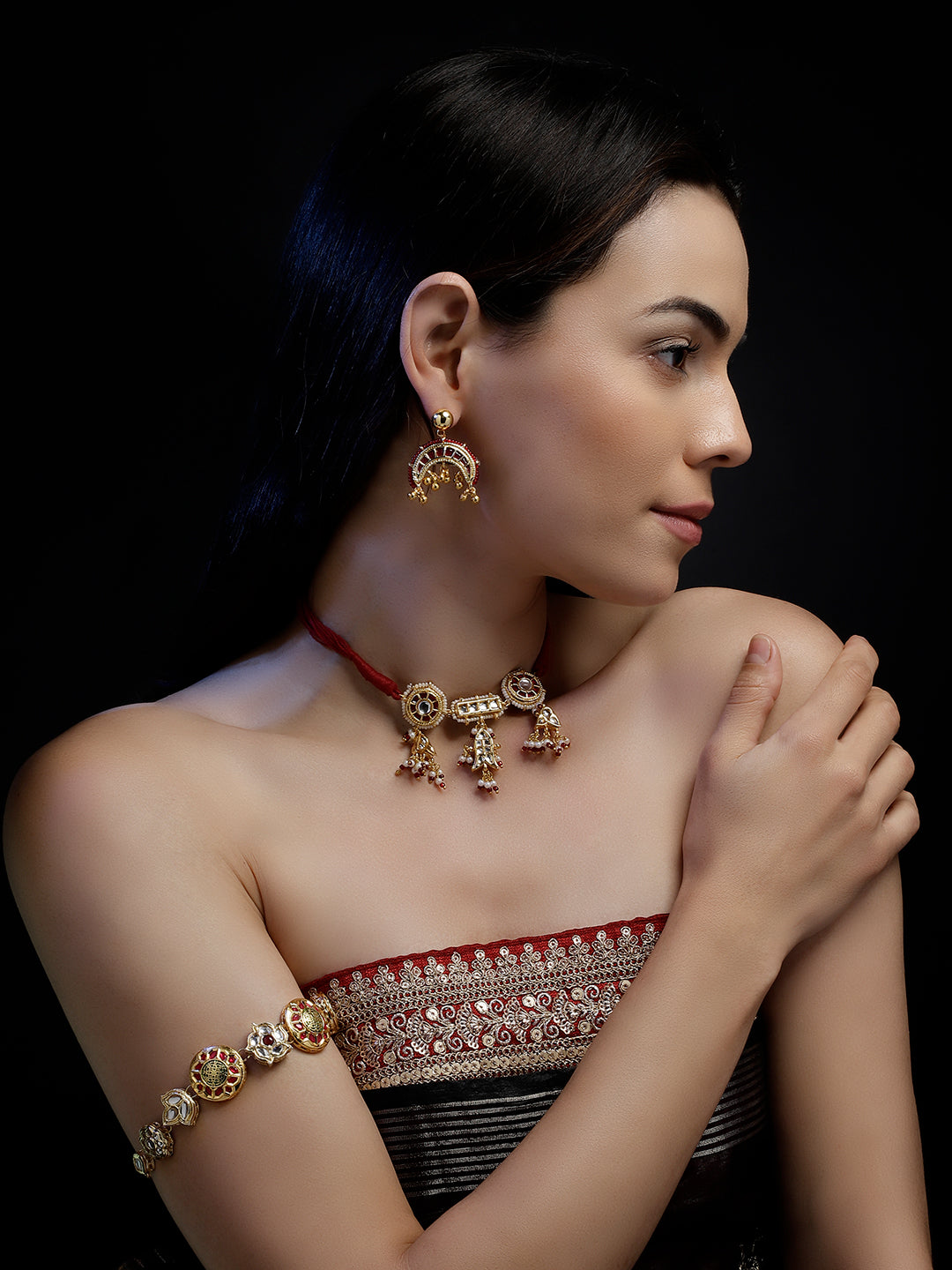 AIVY LUXE red and gold statement earrings worn by woman with matching necklace and bracelet