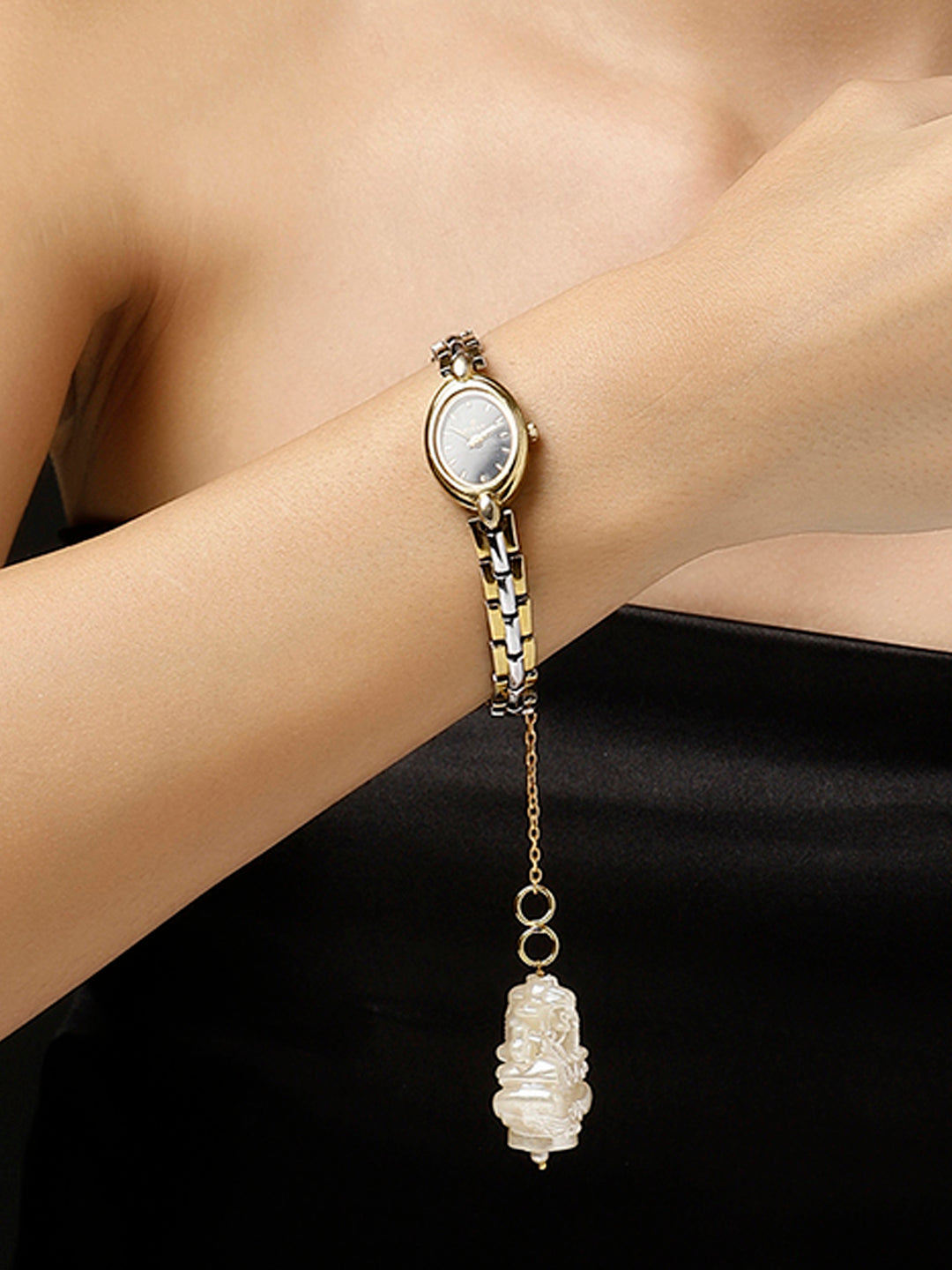 AIVY LUXE Shaandar Zar luxury charm hanging from a gold and silver watch on a woman’s wrist
