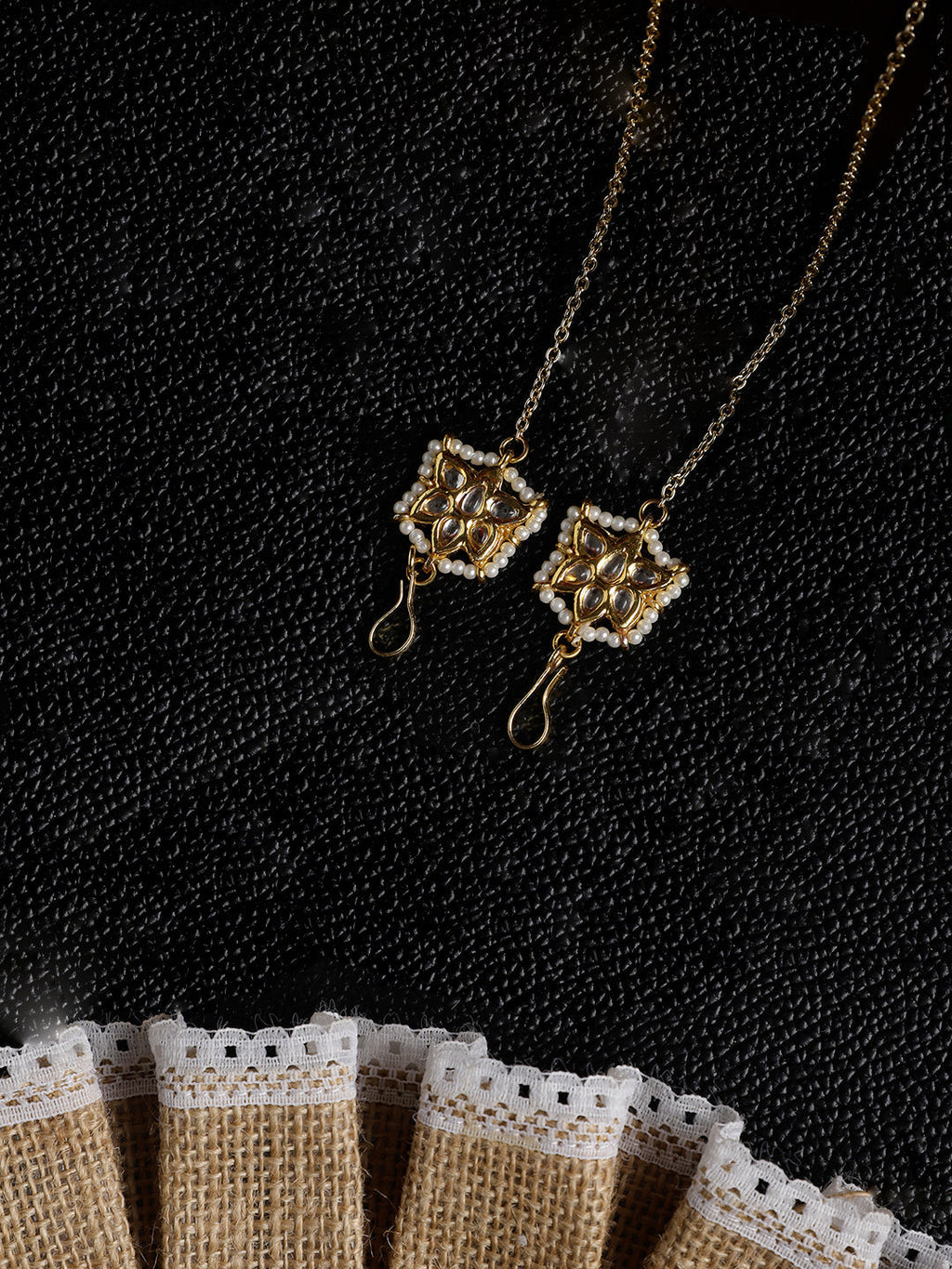 AIVY LUXE Shamsi Glow Drop Earring in gold with intricate design and pearl accents on black textured background