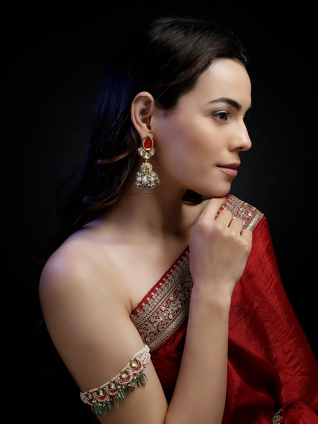 AIVY LUXE traditional gemstone bajuband worn on arm with intricate stones and green beads paired with red saree