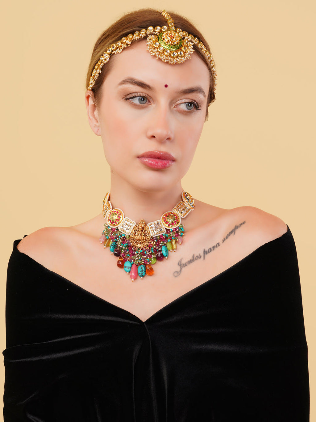 Colourful authentic Indian necklace by AIVY LUXE worn with matching gold headpiece on woman in black dress